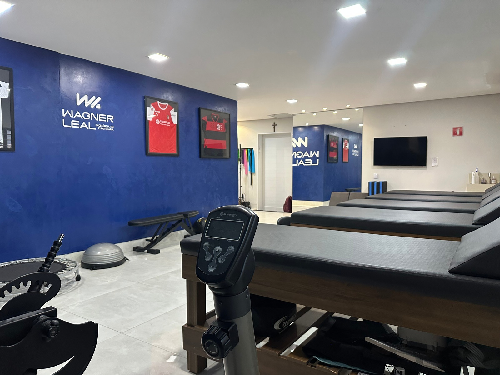 Outro ângulo da sala de fisioterapia da clínica Wagner Leal, destacando macas e equipamentos terapêuticos